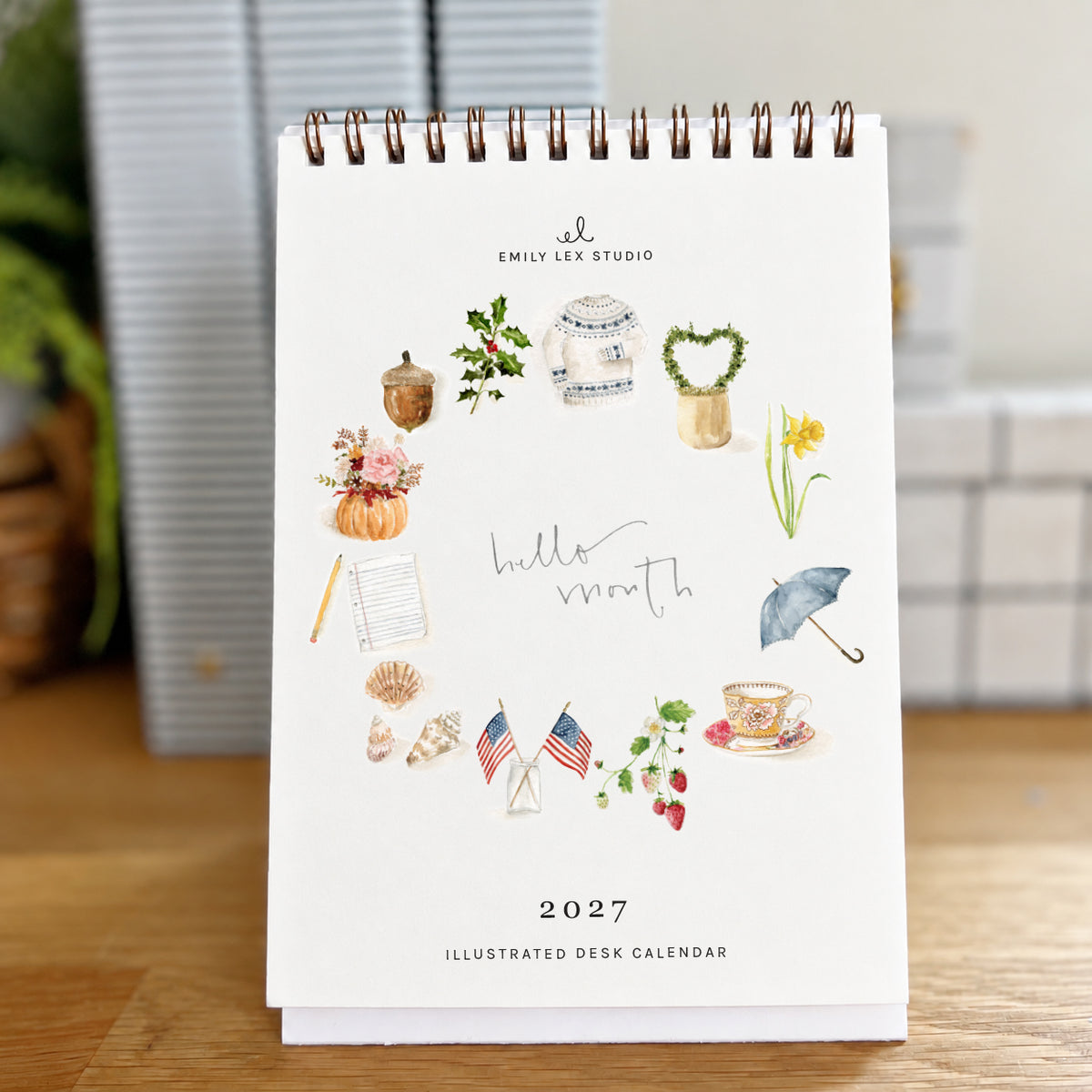 2027 hello month desk calendar cover with a ring of watercolor seasonal icons around the words hello month