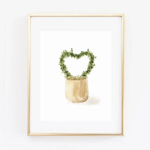 Heart topiary watercolor wall art print of a green heart-shaped topiary in a tan pot, shown in a gold frame