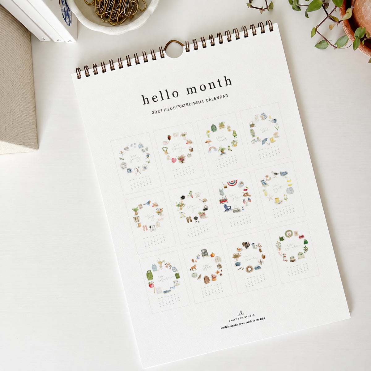 2027 hello month wall calendar back showing a grid of all 12 monthly pages with watercolor icon wreaths