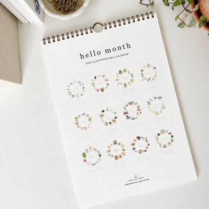 2027 hello month wall calendar back showing a grid of all 12 monthly pages with watercolor icon wreaths