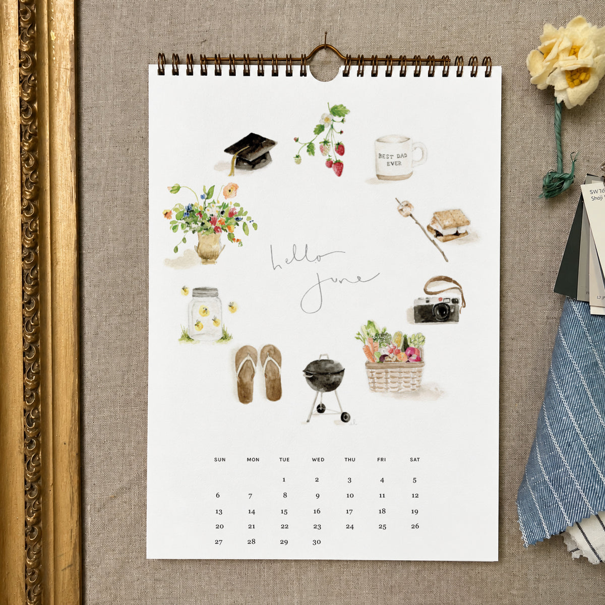 2027 hello month wall calendar June page with watercolor summer icons like strawberries, a camera, a grill, and flip-flops